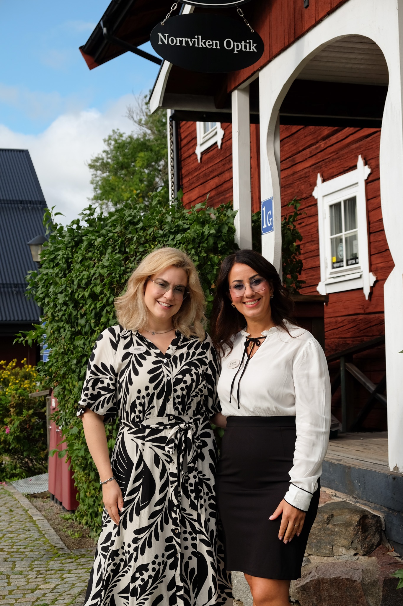 Unni La Fleur Rosengren, leg optiker och Gaida Kareem, leg optiker sitter framför entrén till Norrviken Optik